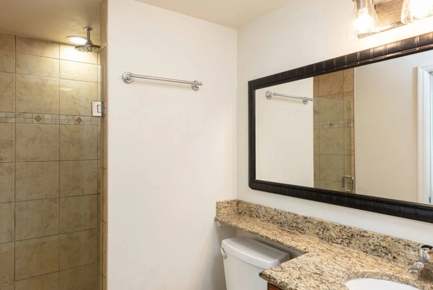 Bathroom in a Westgate Myrtle Beach Oceanfront one-bedroom ocean view with a granite vanity, framed mirror and tiled shower