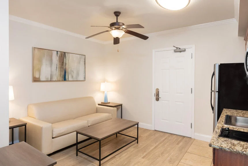 Living room of a Westgate Myrtle Beach Oceanfront one-bedroom ocean view with a white sofa, coffee table and ceiling fan