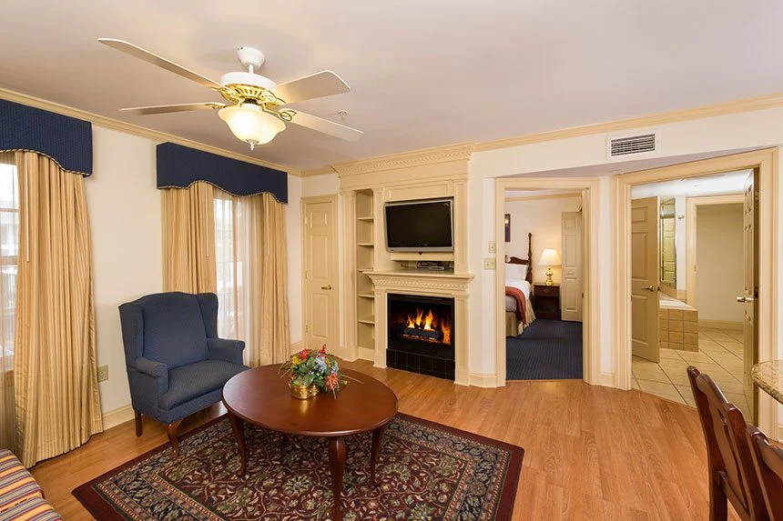 Living room of a Westgate Historic Williamsburg Resort two-bedroom deluxe villa with a fireplace and blue armchair