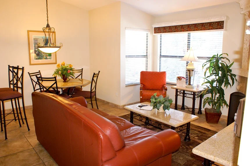Living area of a Westgate Flamingo Bay one-bedroom villa with a red leather sofa, bar stools and dining table