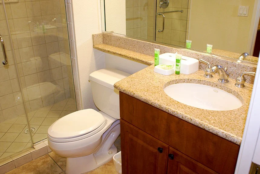 Bathroom in a Westgate Flamingo Bay two-bedroom villa with a granite vanity, toilet and glass-enclosed shower
