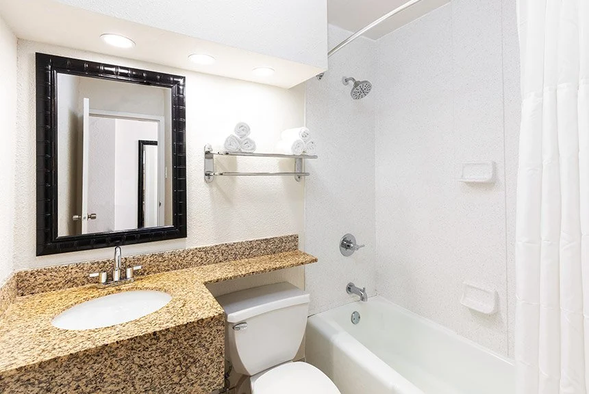 Bathroom in a Westgate Myrtle Beach Oceanfront double amusement park view room with a granite vanity and tub-shower