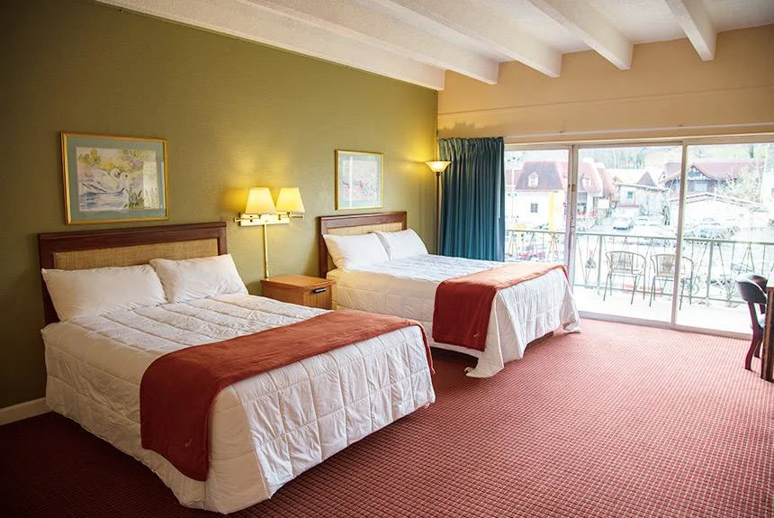 River Terrace Resort river view room with two queen beds, a green accent wall and balcony doors