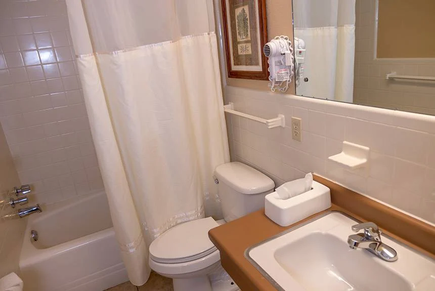 River Terrace Resort bathroom with a tub and shower curtain, toilet, grab bar and sink