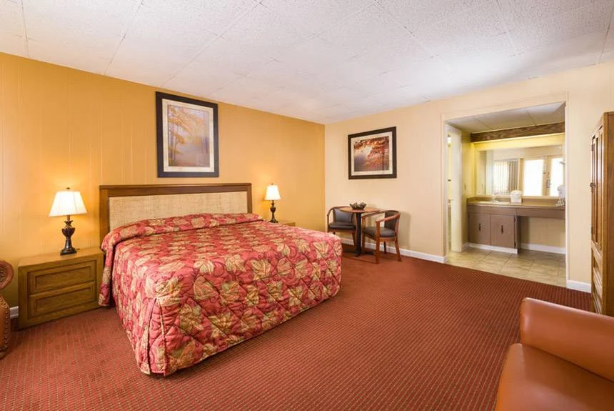 River Terrace Resort standard queen room with a red floral bedspread, orange walls and a vanity area