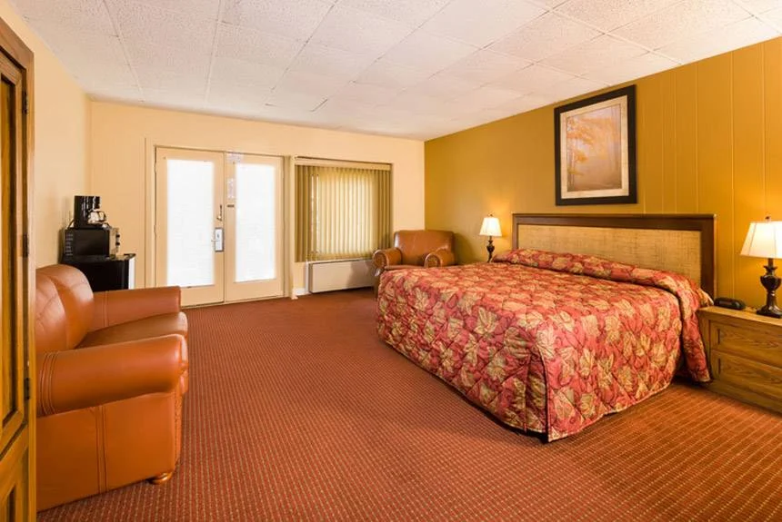 River Terrace Resort standard queen room with a floral bedspread, leather armchair and French doors