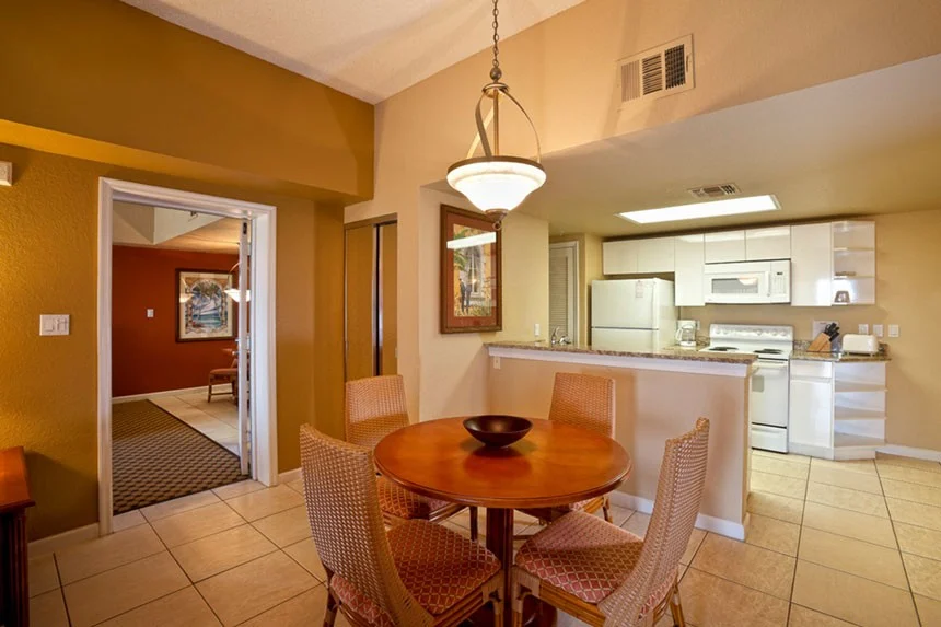 Round dining table and kitchen with white appliances and a breakfast bar in a Westgate Towers Resort two-bedroom villa