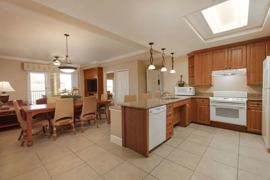 Kitchen and dining area of a Westgate Town Center Resort two-bedroom deluxe villa with white appliances and pendant lights