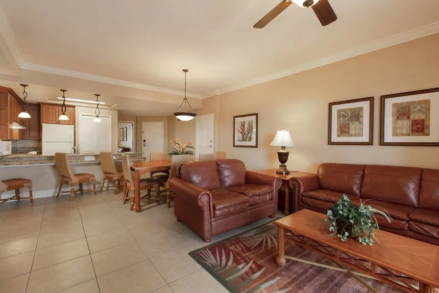 Westgate Town Center Resort two-bedroom deluxe villa living room with leather seating, a dining table and kitchen bar