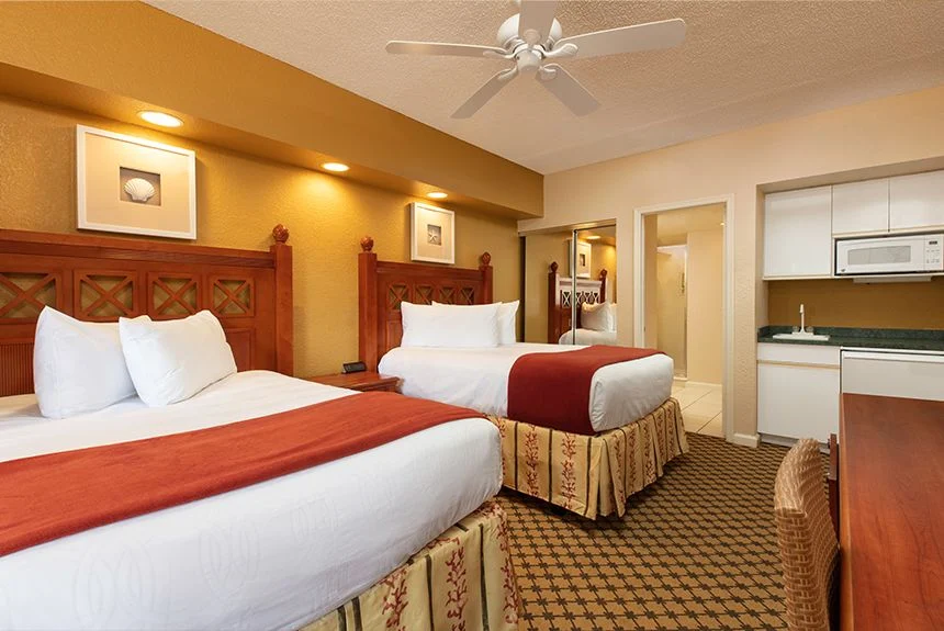 Two beds and a kitchenette with a microwave in a Westgate Vacation Villas Resort studio