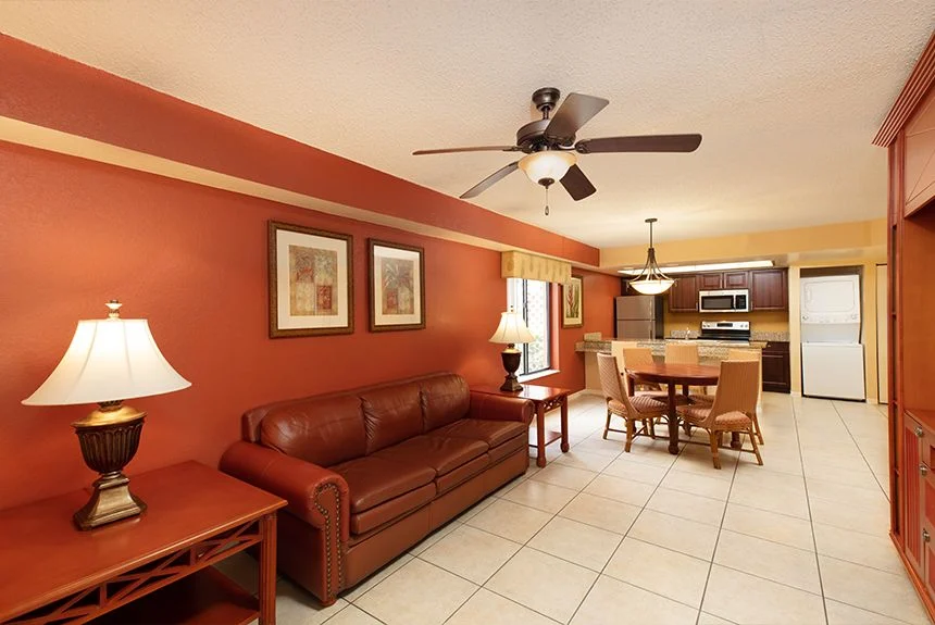 Westgate Vacation Villas Resort two-bedroom villa living room with a leather sofa, dining table and kitchen beyond