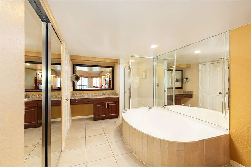 Bathroom in a Westgate Vacation Villas Resort two-bedroom villa with loft, with a corner tub and glass shower