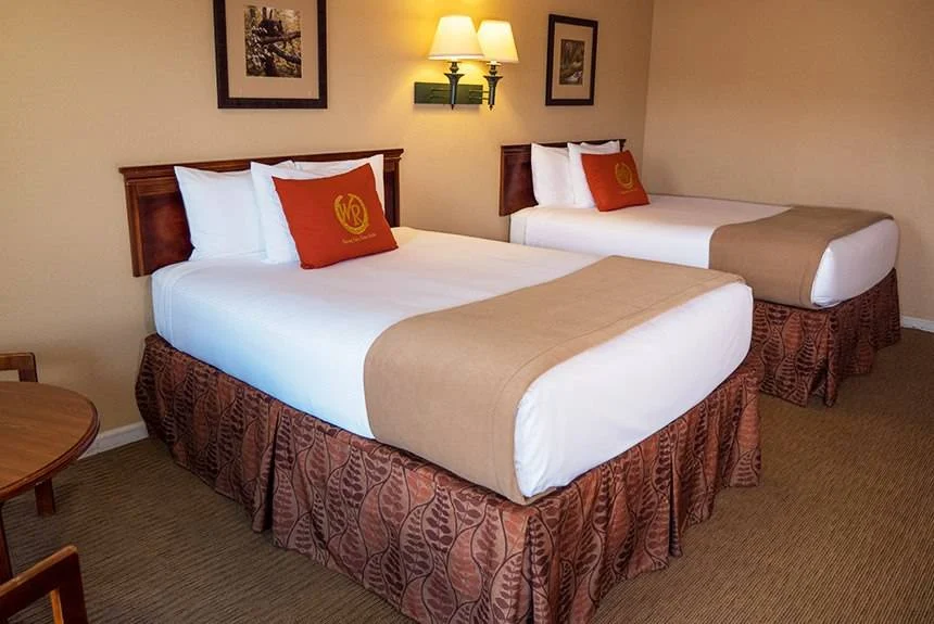 Wild Bear Inn double queen poolside guest room with two beds, framed pictures and wall sconces