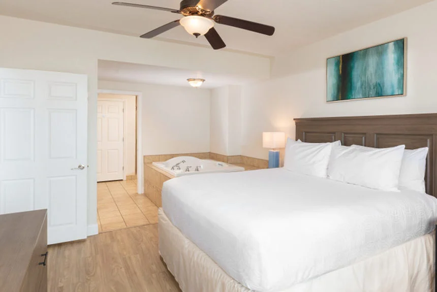 Bedroom in a Westgate Myrtle Beach Oceanfront two-bedroom ocean view with a bed, teal abstract art and a jetted tub