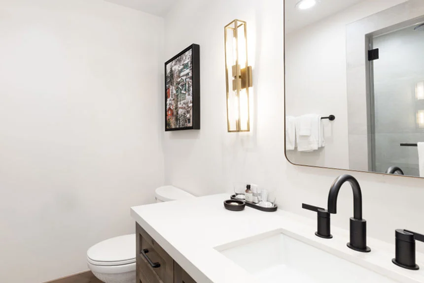 Bathroom of a Westgate Park City Resort & Spa studio premier with a white vanity, black faucet and wall sconce