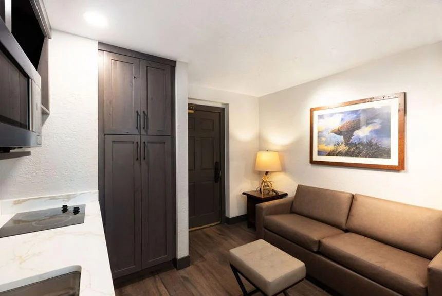 Westgate Park City Resort & Spa studio villa with a brown sofa, ottoman, tall cabinet and cooktop counter