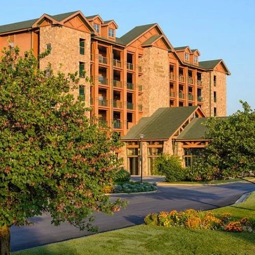 Stone lodge-style building of Westgate Branson Woods Resort with green roofs and a curved driveway