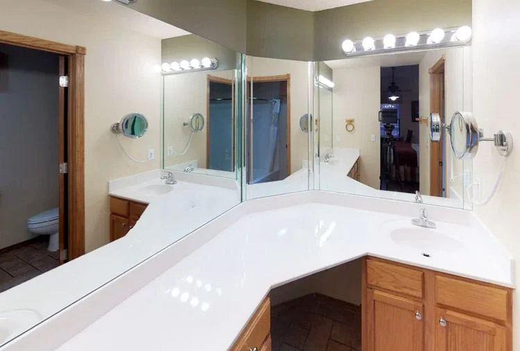 Bathroom in a Westgate Branson Woods studio with a white vanity, large mirrors and a row of vanity lights