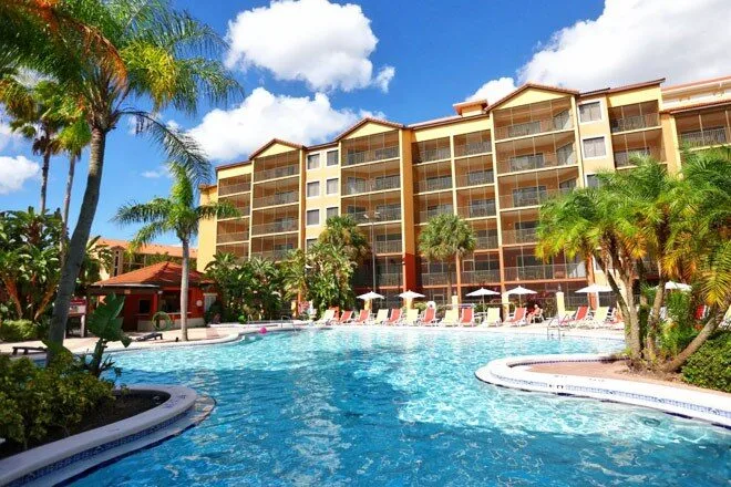 Westgate Lakes Resort building behind the curved blue pool and palms