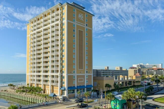 High-rise tower of Westgate Myrtle Beach Oceanfront Resort beside the beach under a blue sky
