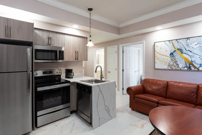 Kitchen and living area of a Westgate Palace Resort two-bedroom villa with stainless steel appliances and leather sofa