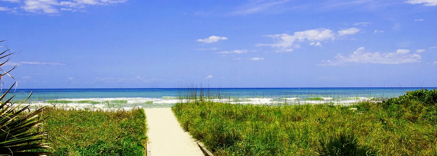 A sandy path through the dunes leading down to the ocean at Cocoa Beach