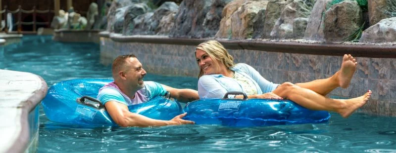 Couple relaxing on inner tubes in the lazy river at Wild Bear Falls indoor water park
