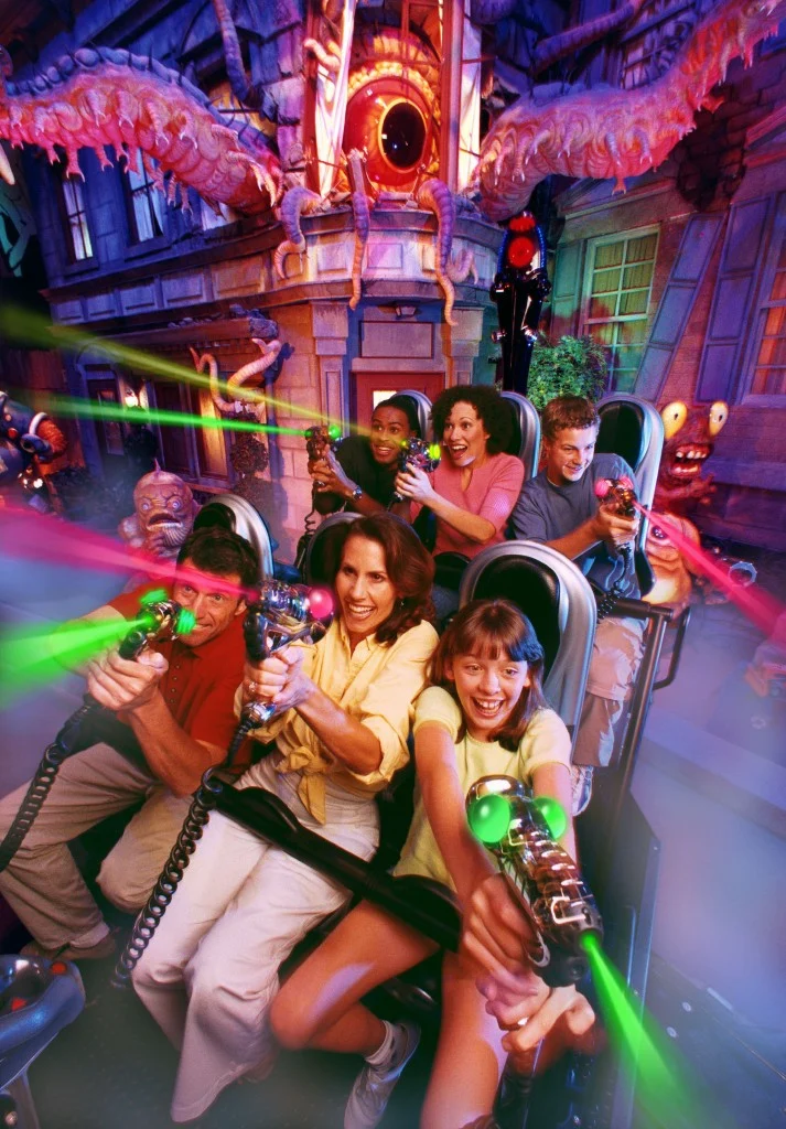 Riders firing laser blasters from a ride vehicle on Men in Black Alien Attack