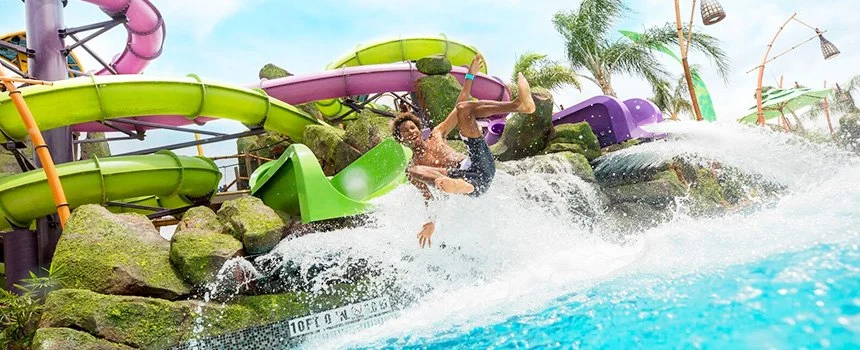 Rider splashing out of a water slide at Universal's Volcano Bay