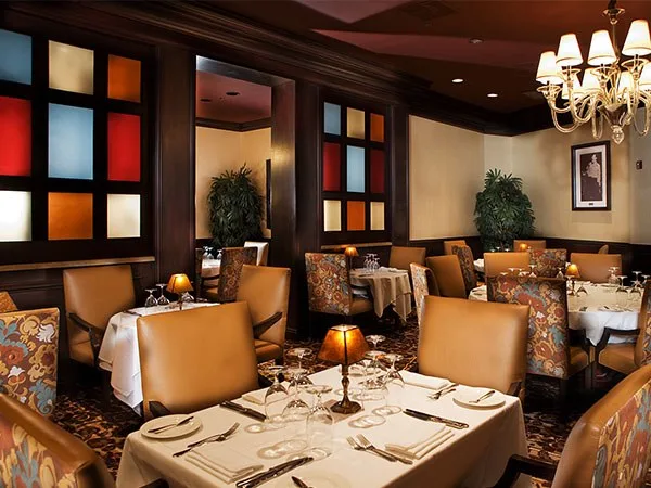 Elegant resort restaurant dining room with a chandelier and colored glass panels